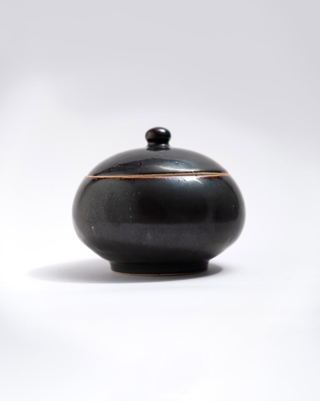 Black ceramic jar with lid on a white background, made in Italy