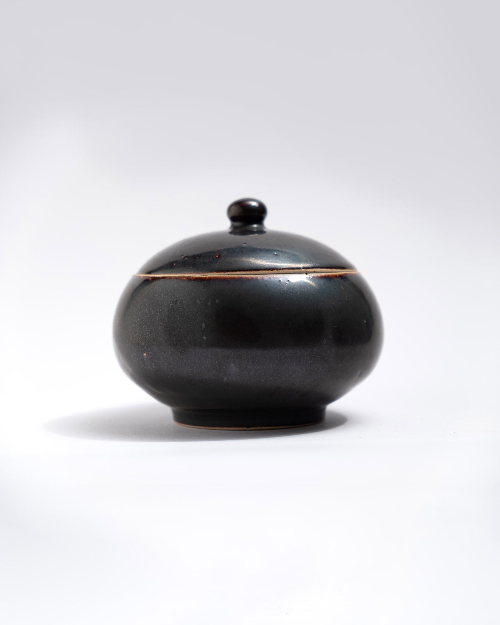 Black ceramic jar with lid on a white background, made in Italy