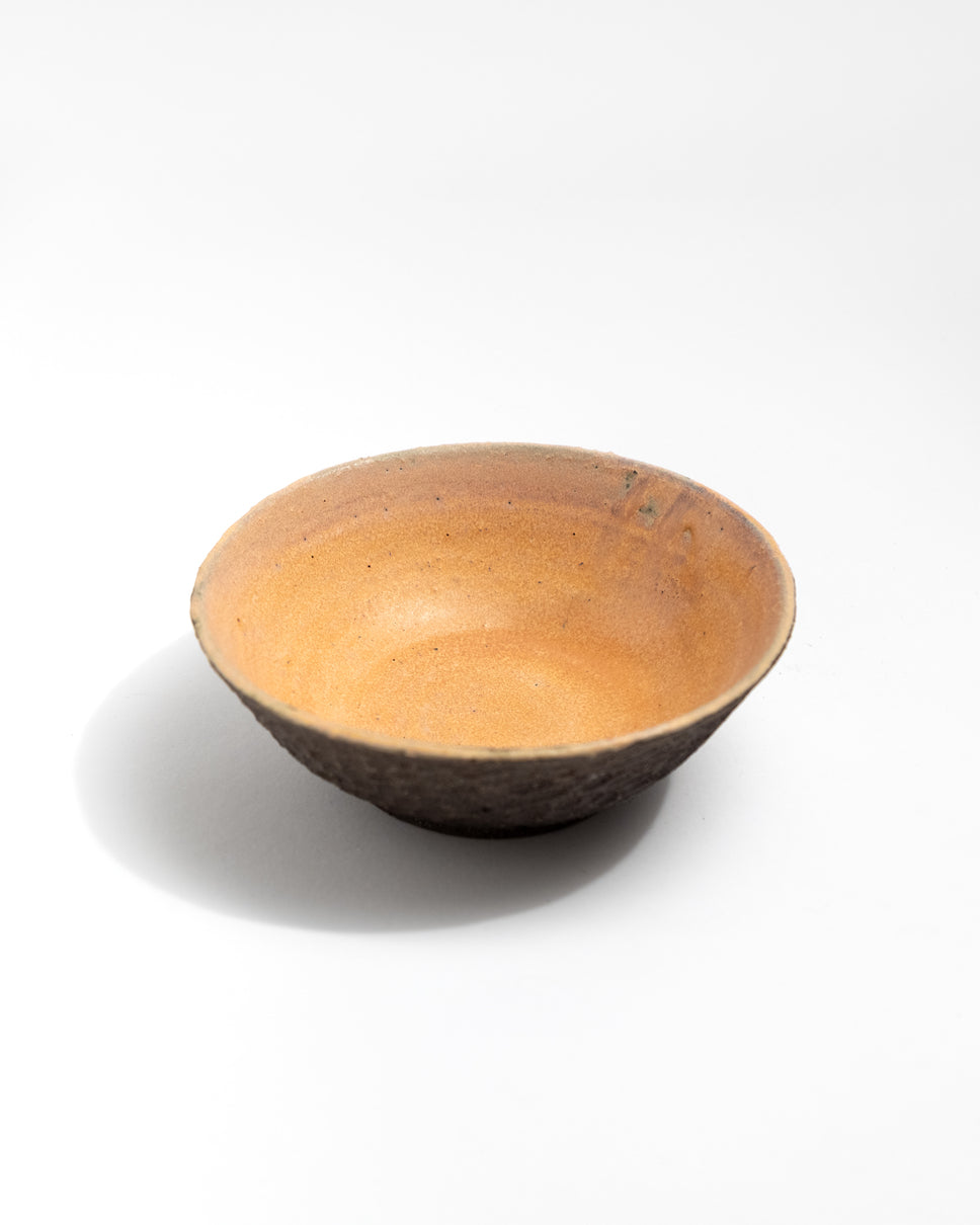 Black clay ceramic bowl on a white background, handmade in Italy