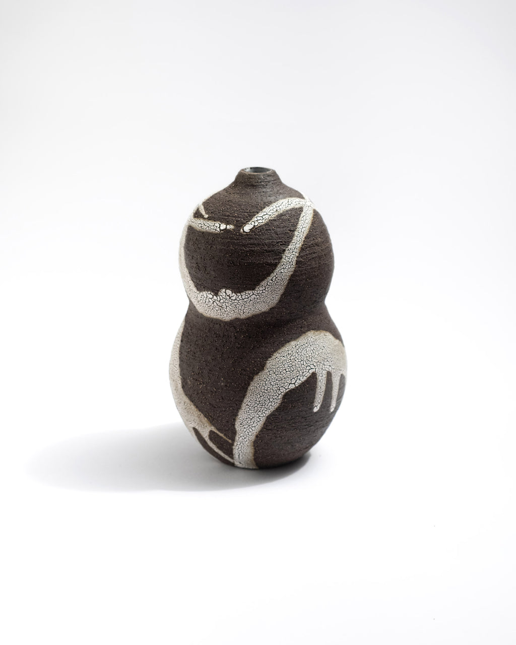 Black clay ceramic vase with abstract design on a white background, handmade in Italy