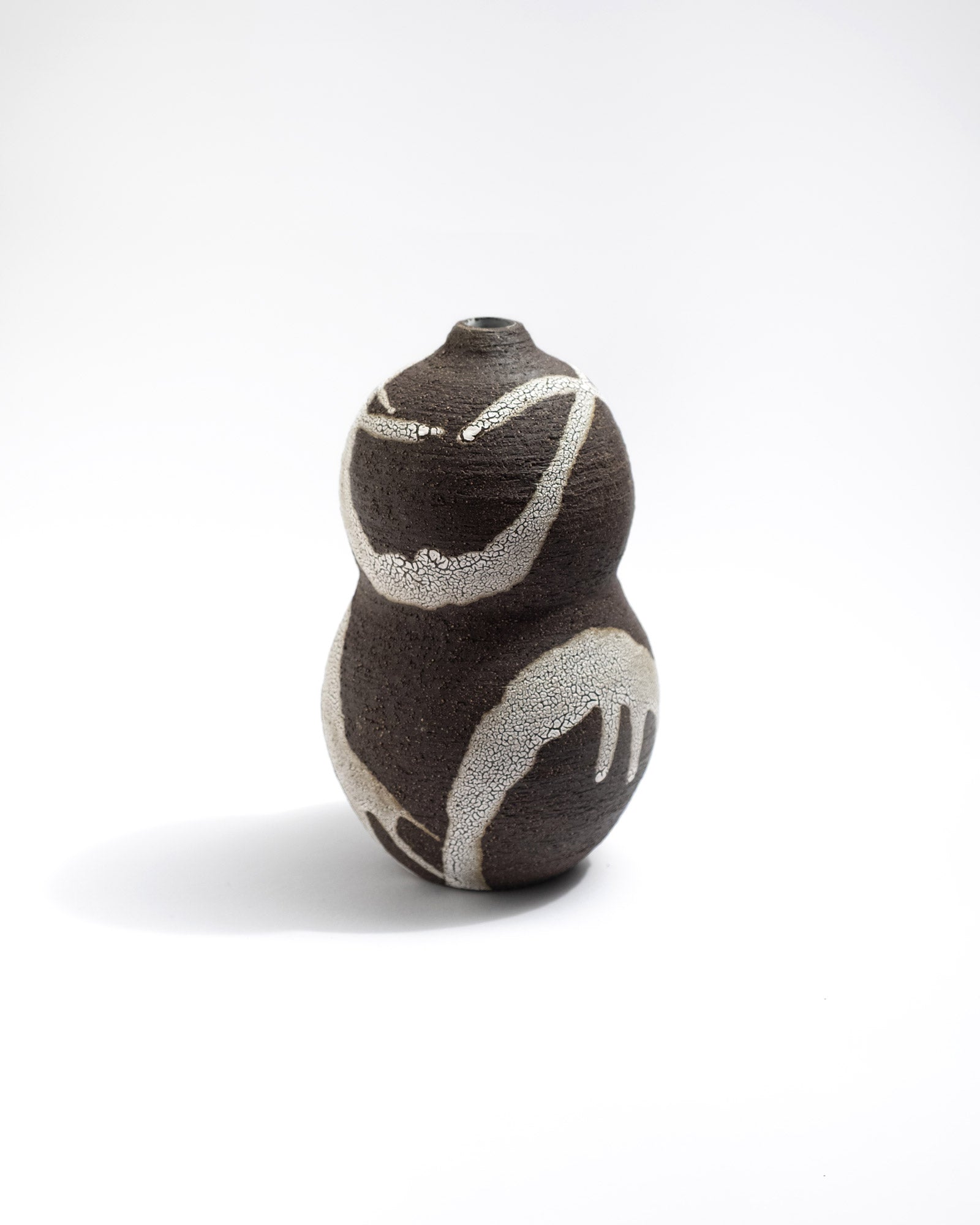Black clay ceramic vase with abstract design on a white background, handmade in Italy