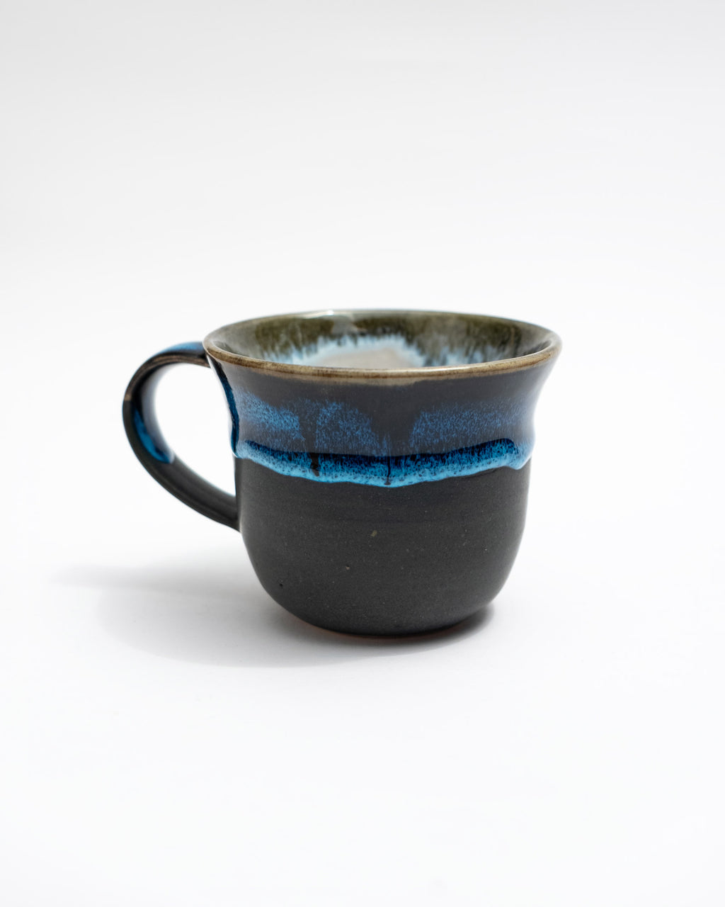 Black ceramic mug with blue interior on a white background, handmade in Rome