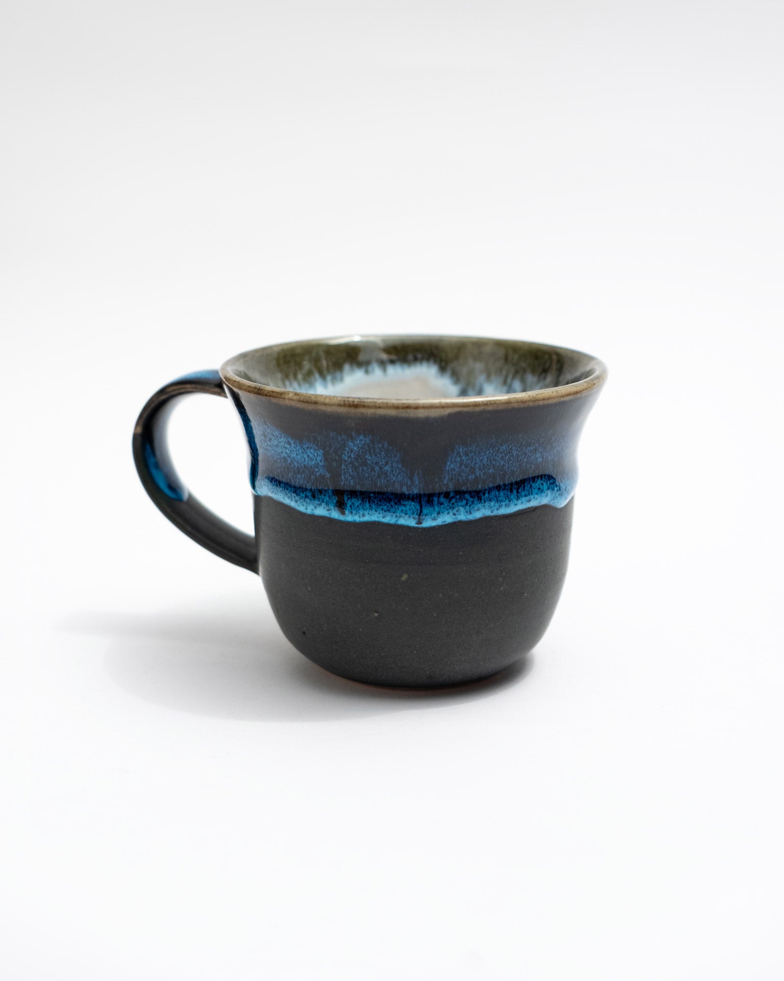 Black ceramic mug with blue interior on a white background, handmade in Rome