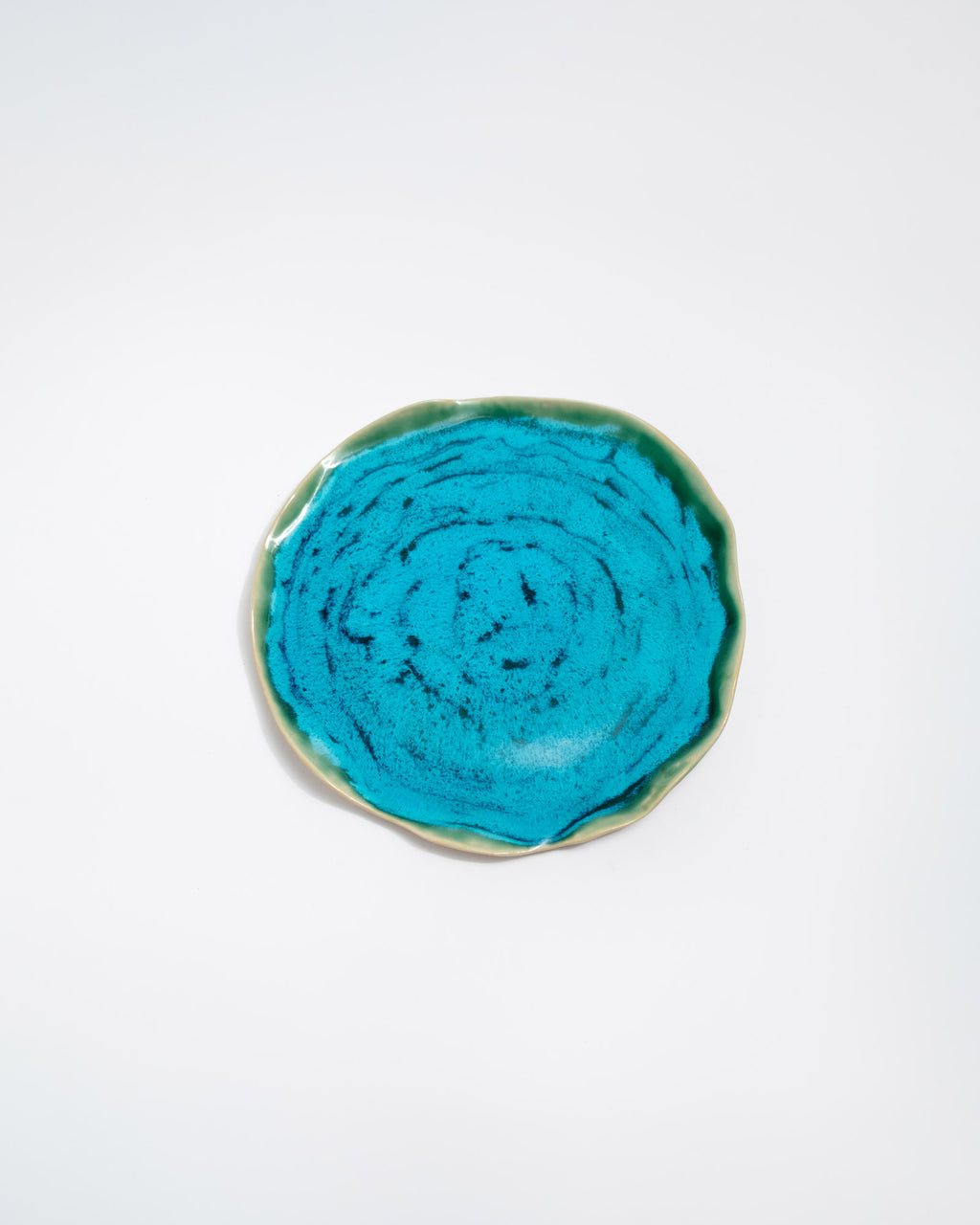 Round turquoise ceramic dish on a white background
