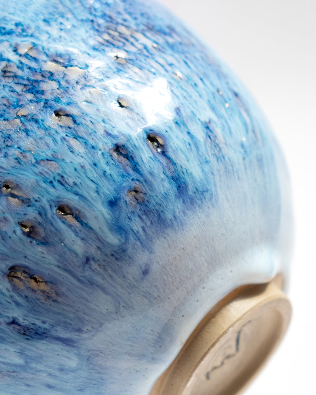 Close-up of a blue ceramic vase with a textured surface, handmade in Italy