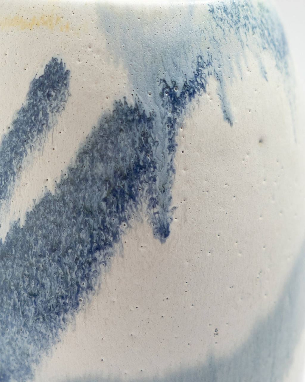 Close-up of a ceramic vase with blue and white glaze patterns