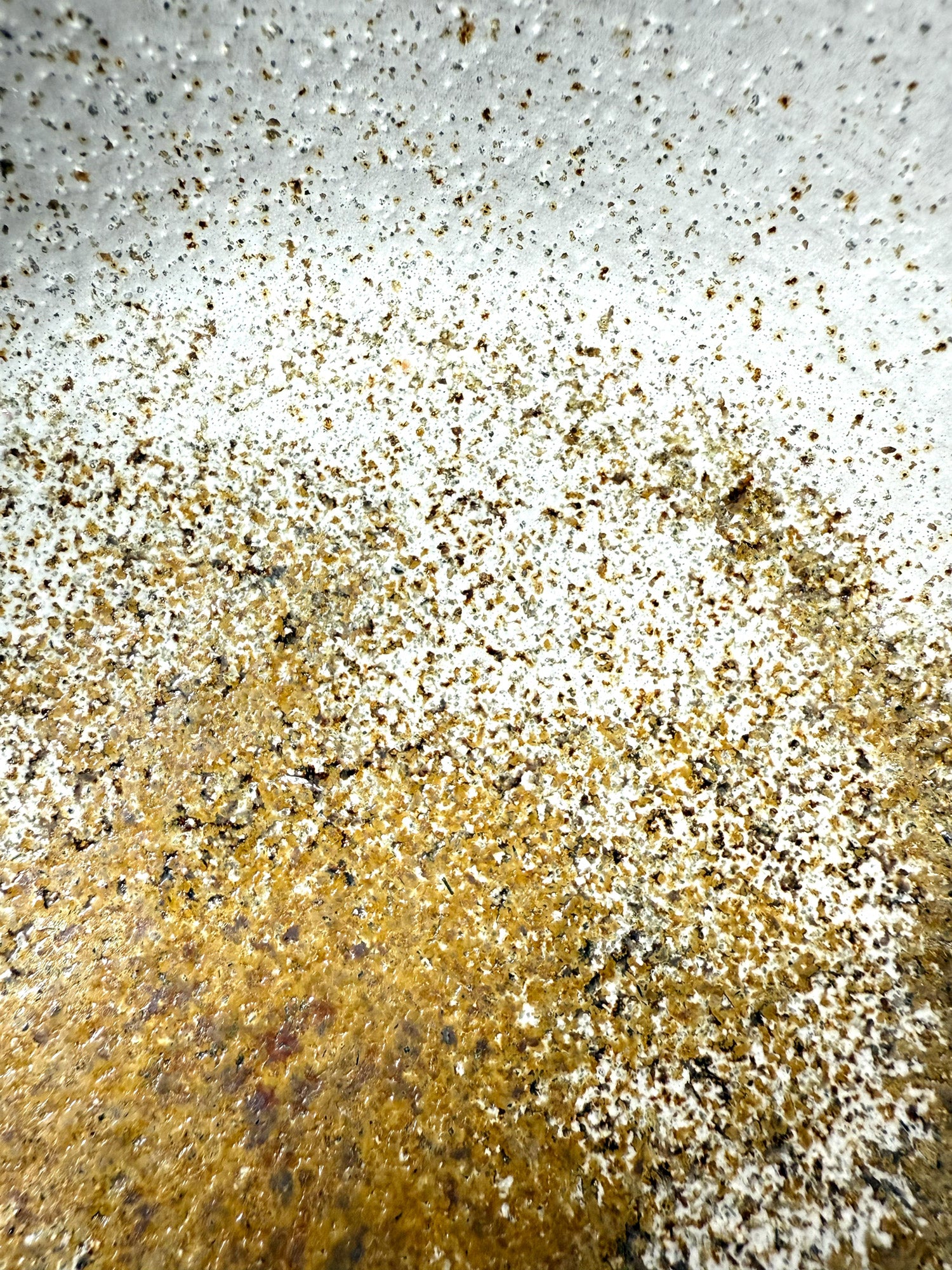 Close-up of a textured surface with gold and white coloration