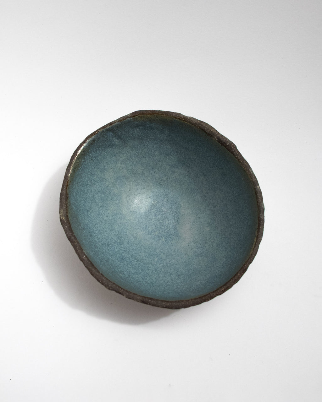 Handmade black stoneware bowl with a fully hand-textured exterior and soft blue glazed interior. Inspired by the look of a dragon’s egg. Artisan ceramic bowl by Malfatto Ceramics