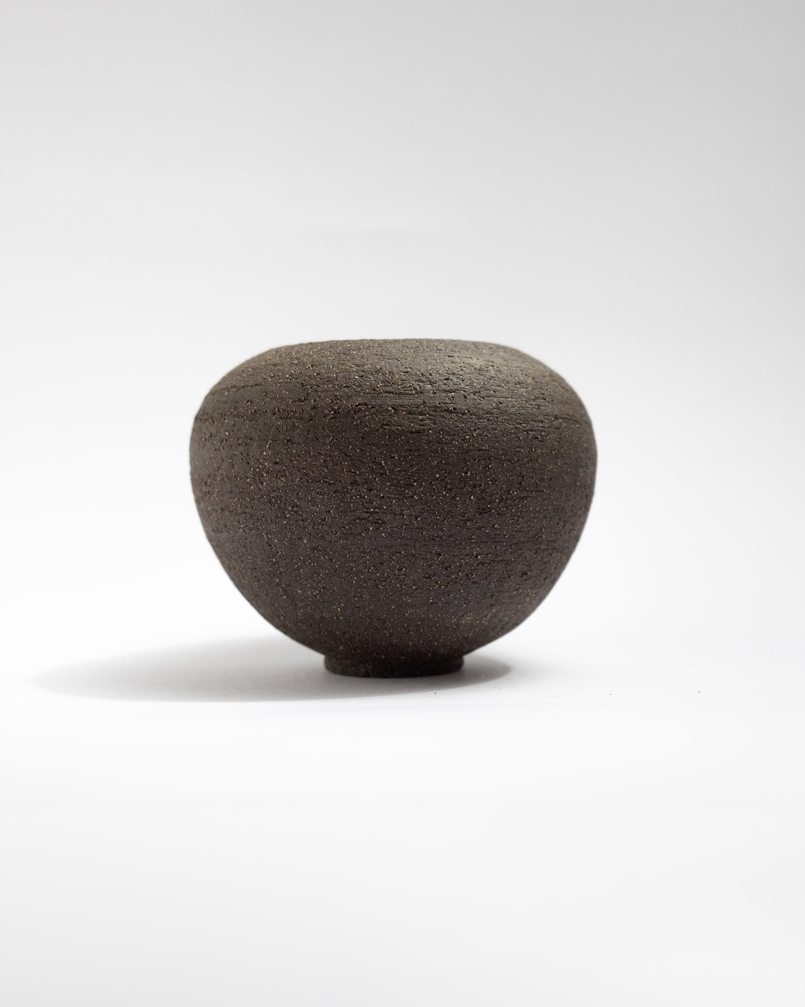 Black clay vase with unglazed exterior and glossy white interior, handmade in Italy