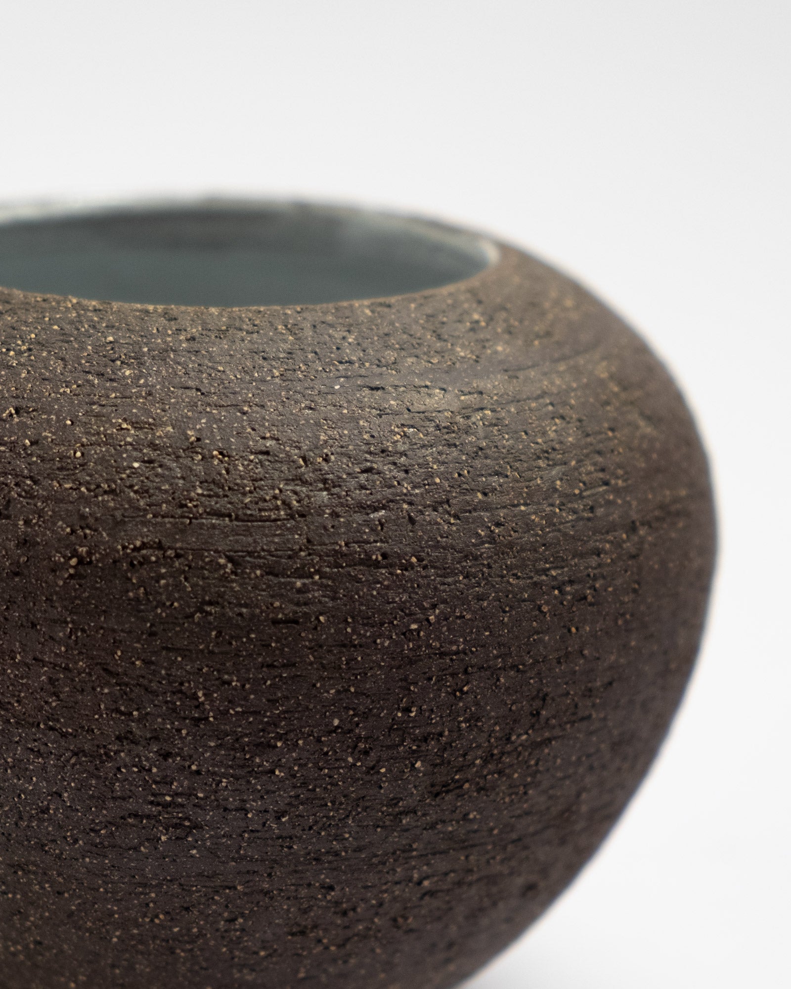 Close-up of a textured black ceramic bowl on a white background