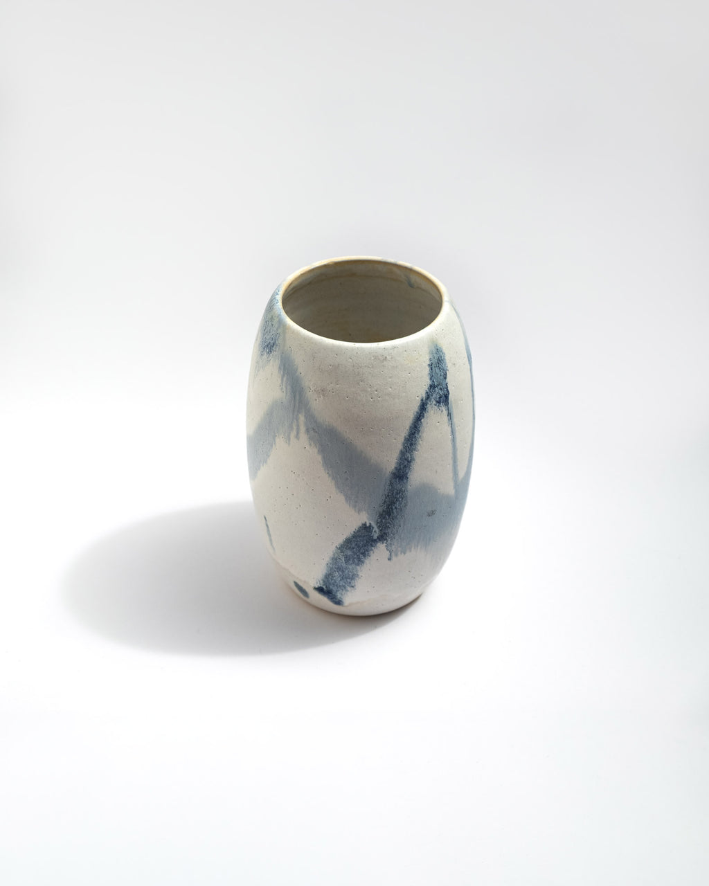 Ceramic vase with blue abstract patterns on a white background