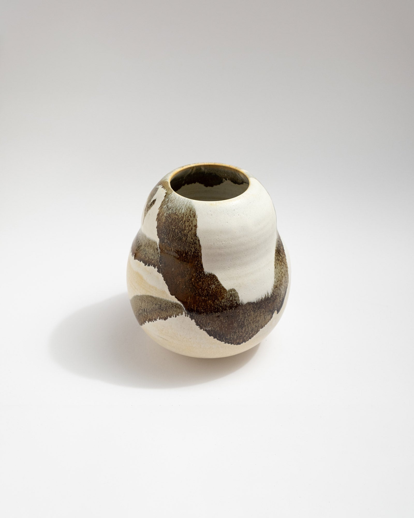Ceramic vase with brown and white pattern on a light gray background