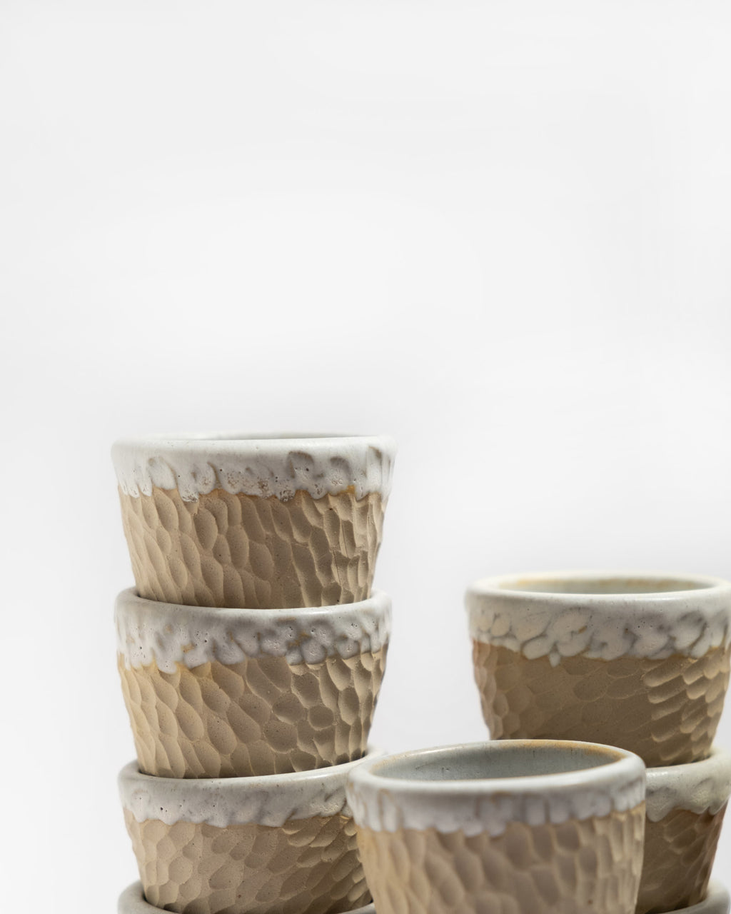Set of ceramic coffee cups with textured design on a white background