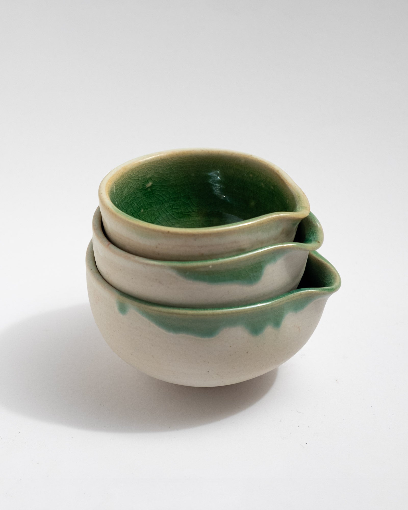 Stack of three ceramic bowls with green interior and white exterior, handmade in Italy, matcha bowls