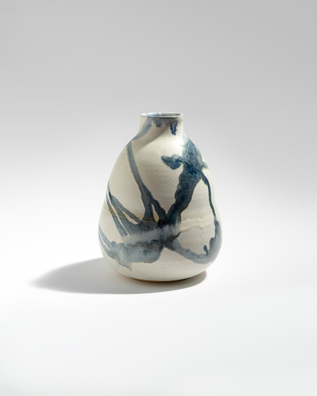 Ceramic vase with abstract blue patterns on a white background