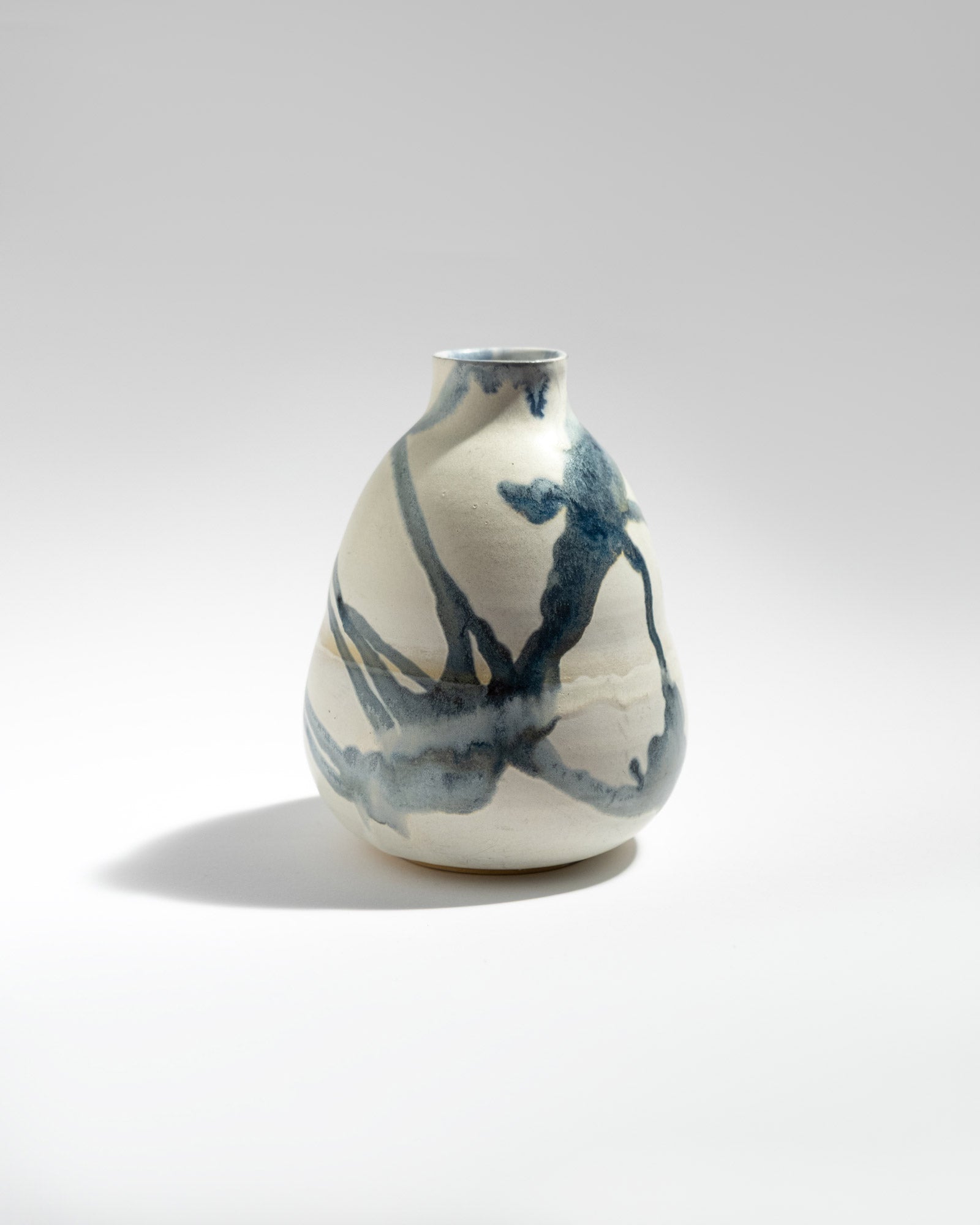 Ceramic vase with abstract blue patterns on a white background