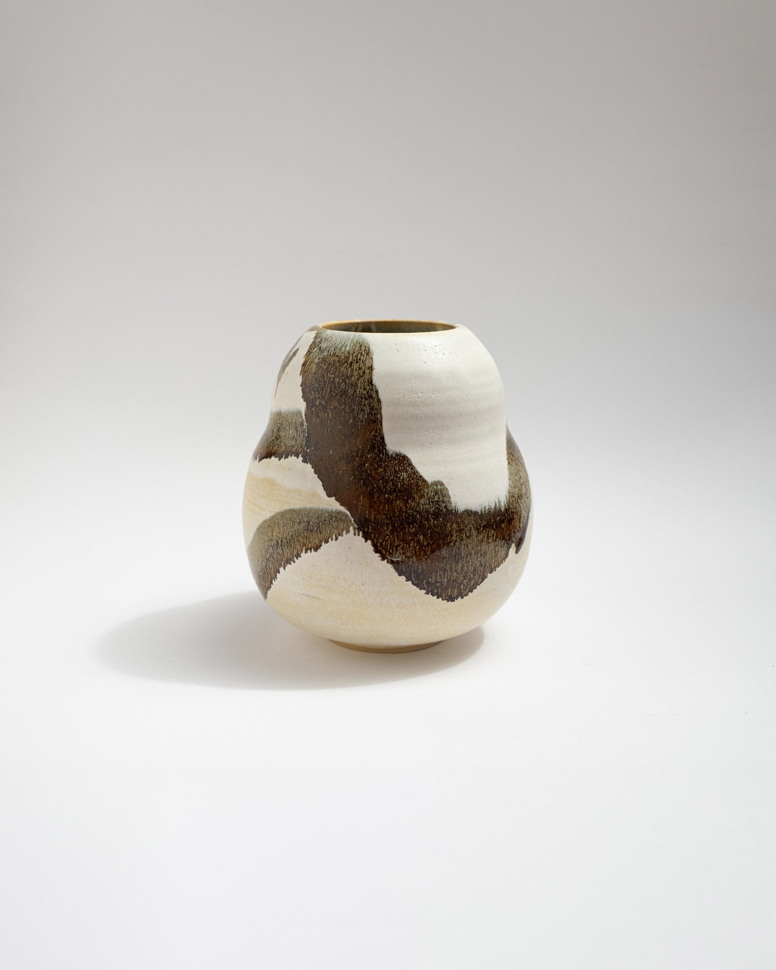 Ceramic vase with brown and white abstract pattern on a light gray background