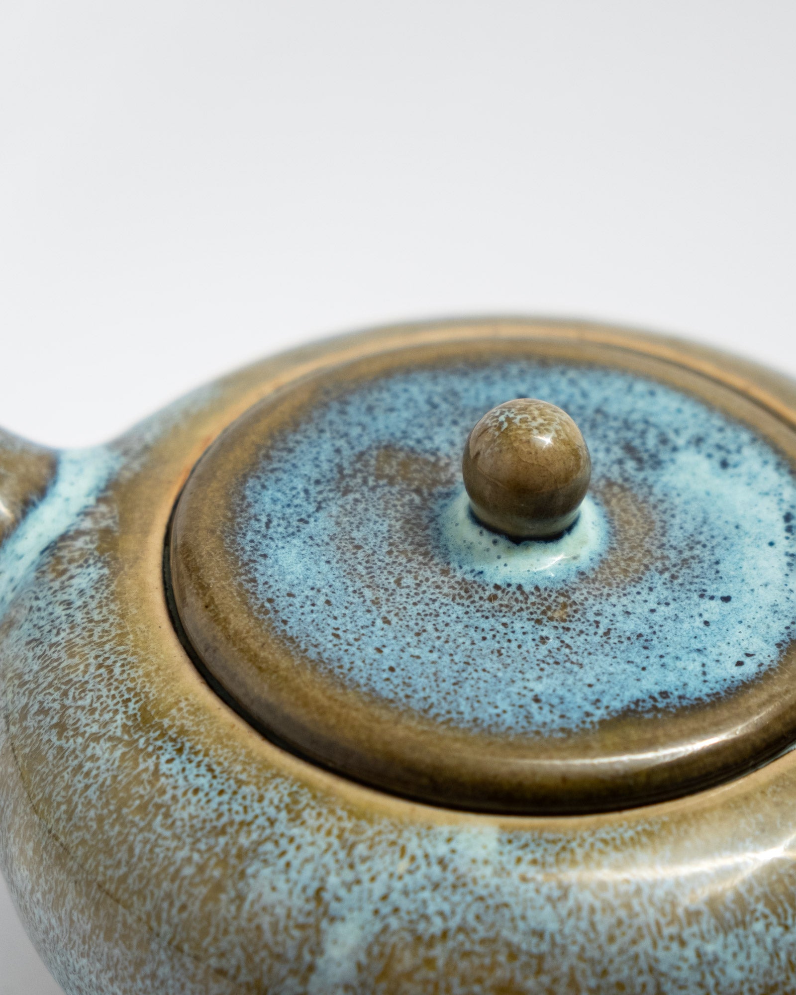 Handmade wheel-thrown stoneware teapot with a flowing blue–brown glaze, rounded form, and clean-pouring spout. Artisan teaware by Malfatto Ceramics