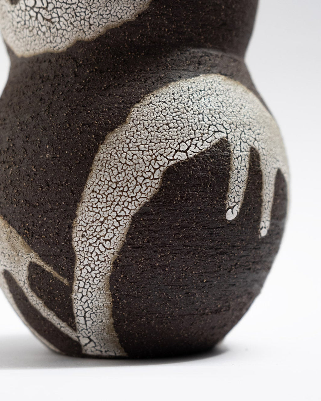 Ceramic vase with black and white crackled glaze pattern on a white background