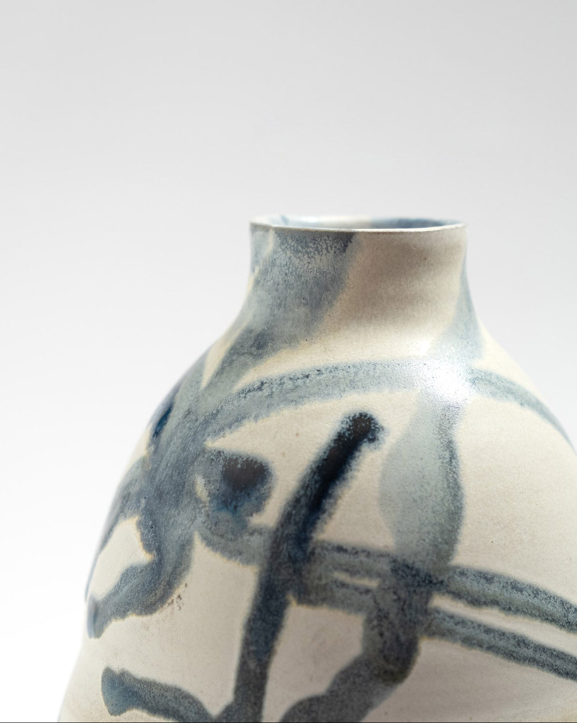 Ceramic vase with blue abstract design on a white background