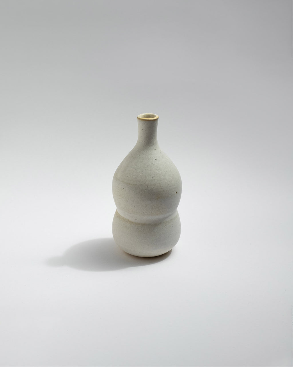 White ceramic vase on a light gray background, handmade in Italy