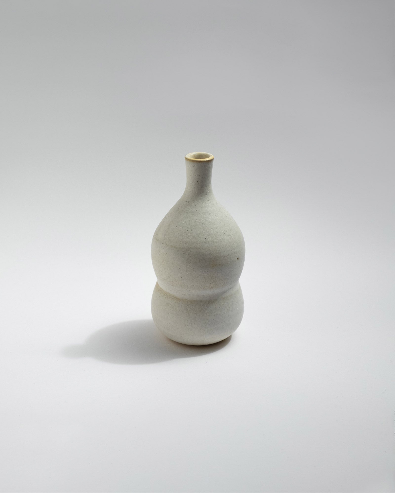 White ceramic vase on a light gray background, handmade in Italy