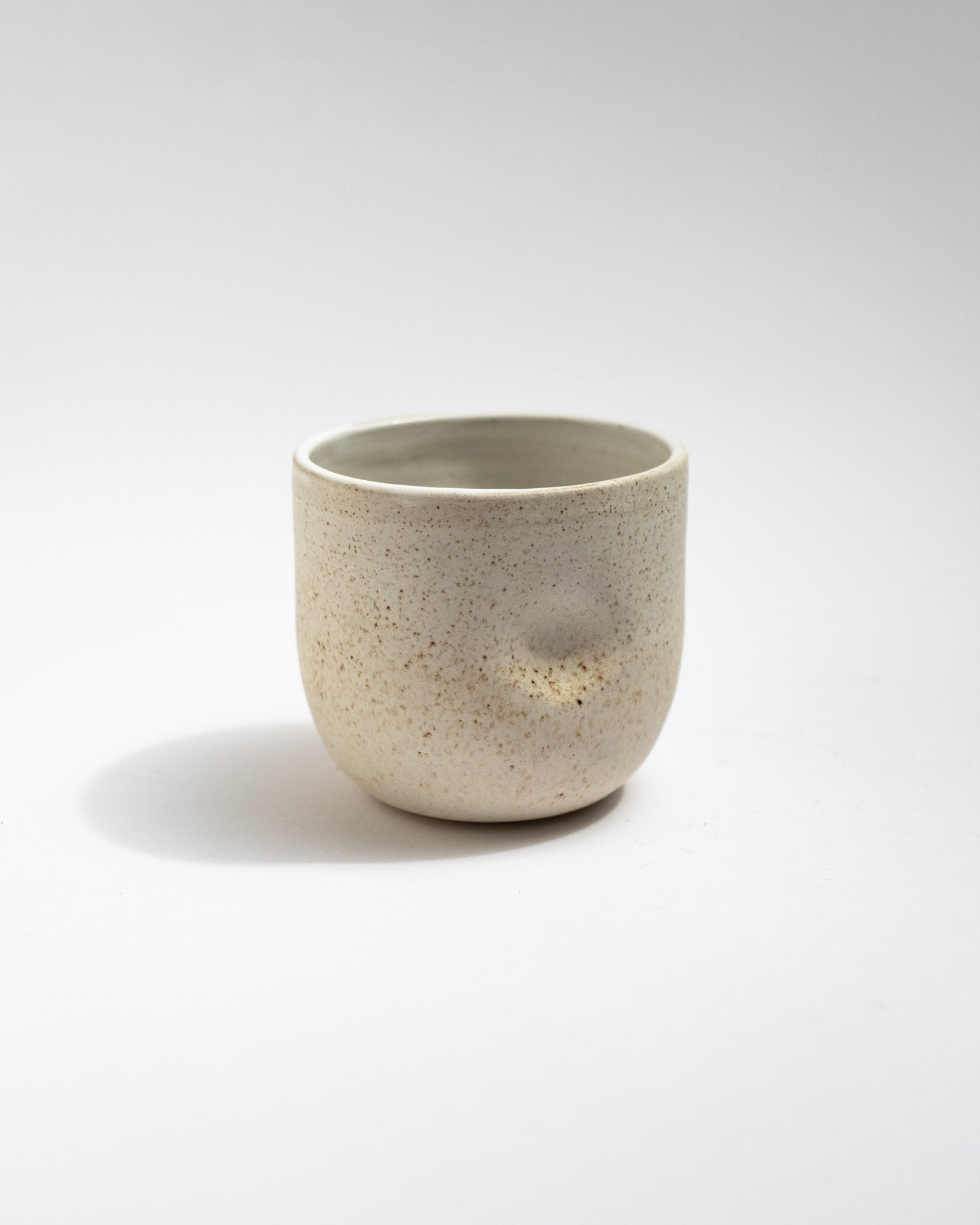 Handmade ivory speckled stoneware cup with soft cylindrical shape