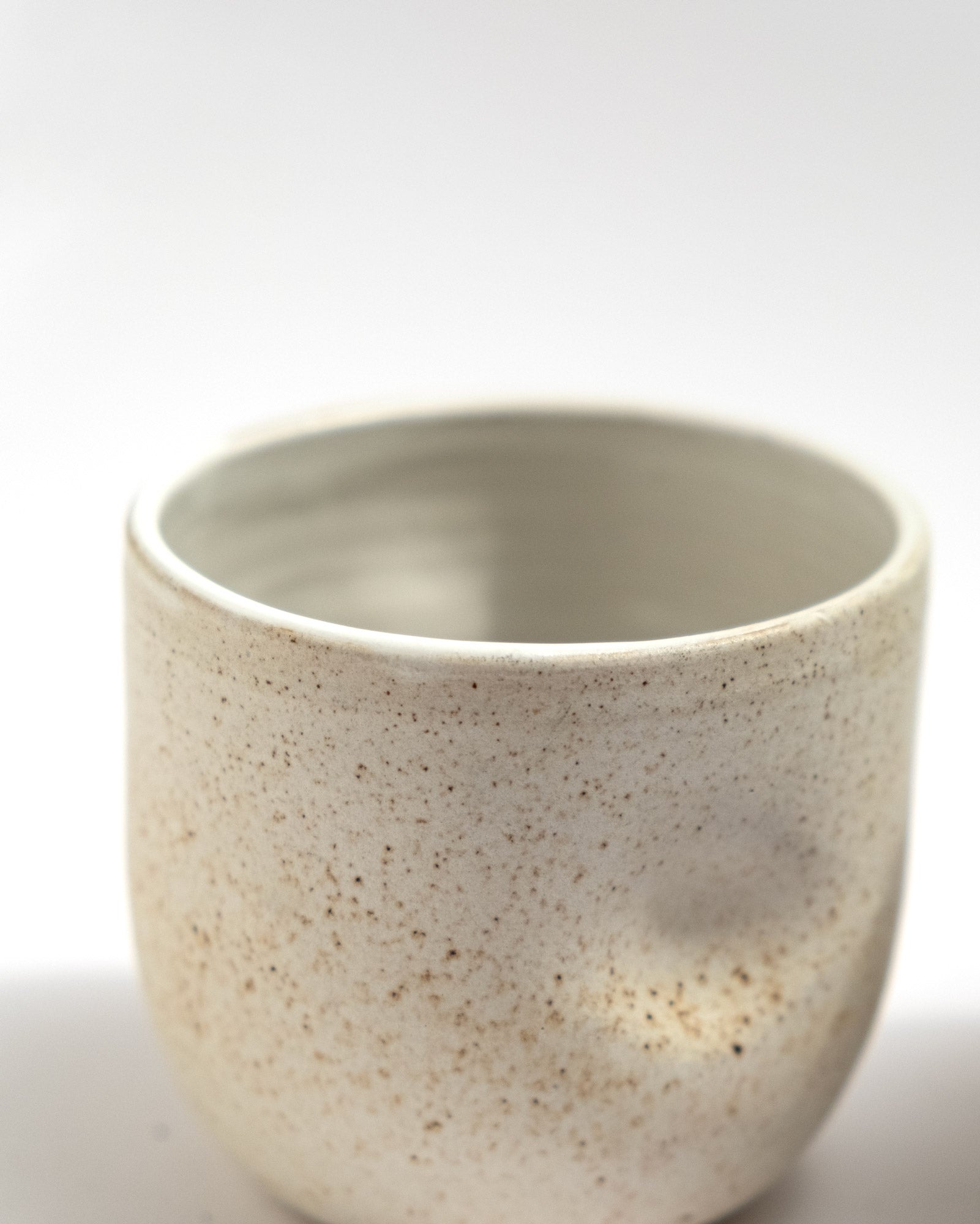 ivory speckled stoneware cup with soft cylindrical shape, handmade in Italy