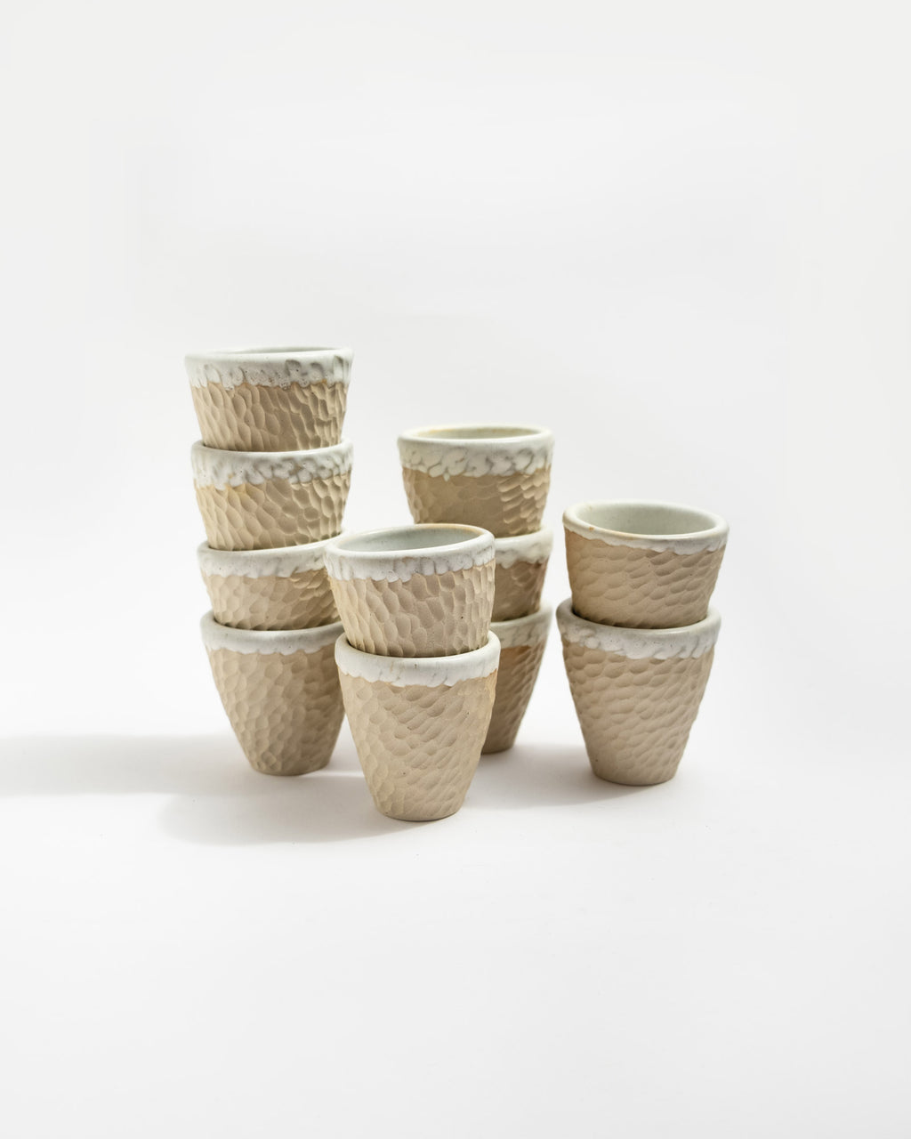 Set of ceramic coffee cups with textured surfaces on a white background, handmade in Italy