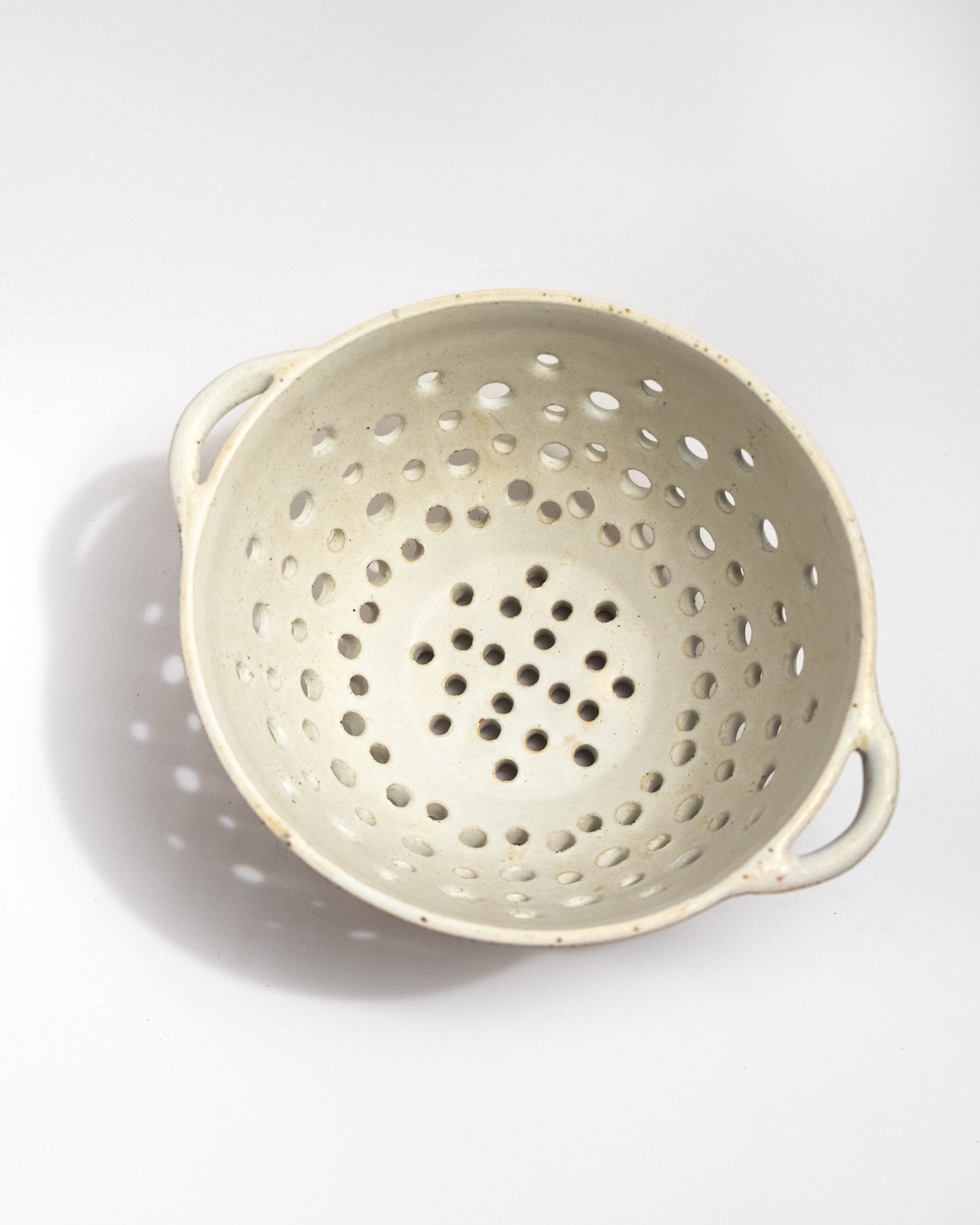 Beige colander on a white background