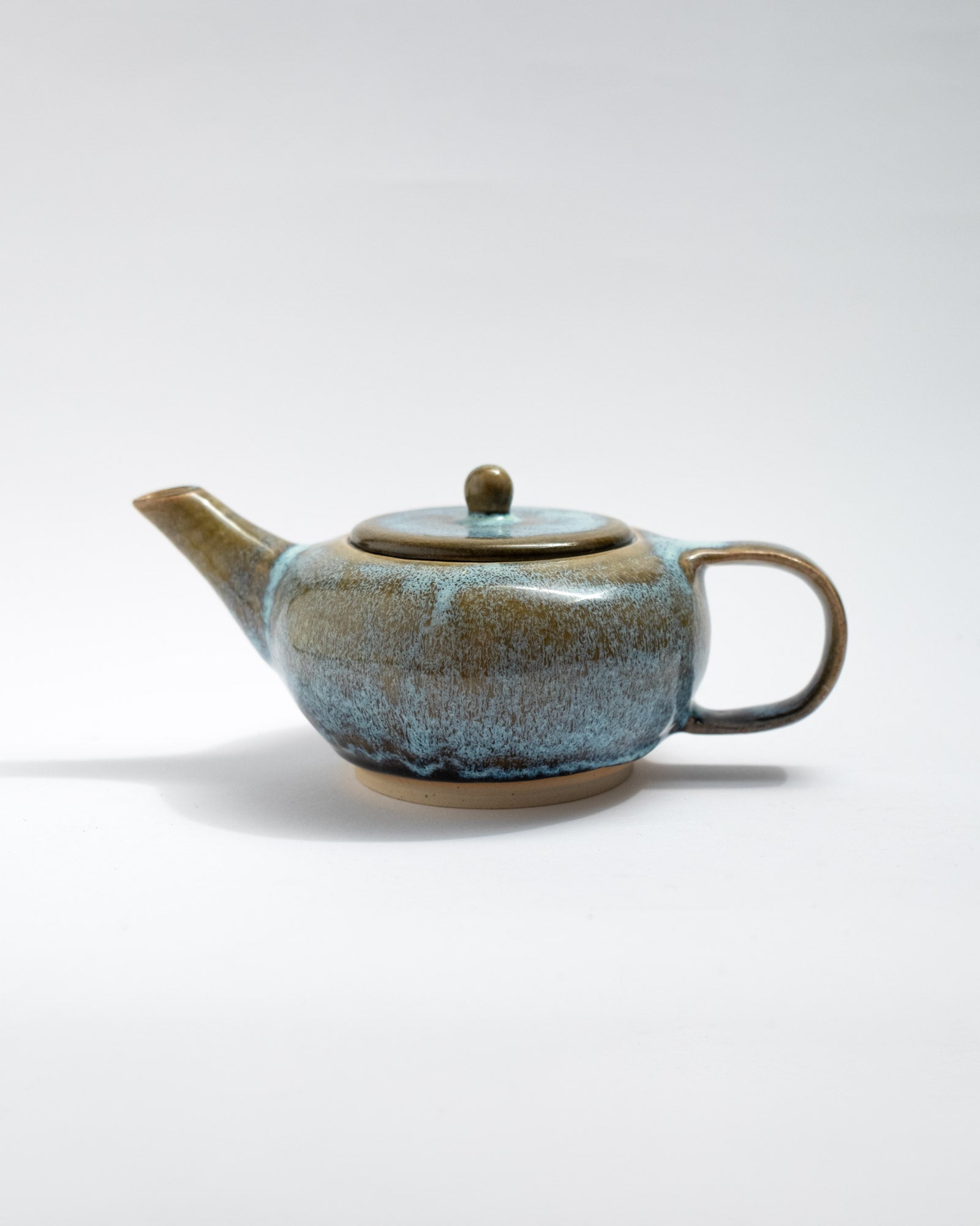 Handmade blue and brown stoneware teapot with flowing glaze and rounded body